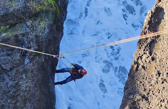 Image depicts high angle rope rescue over an ocean inlet high tide water surge channel to represent imagery for Crux Rescue's Instructor Training course, otherwise known as Train The Trainer rope rescue courses.